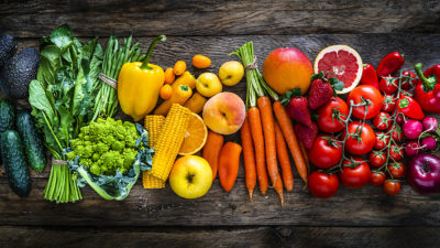 Healthy fresh fruits and vegetables arranged in a rainbow row, showing how foods may impact anxiety symptoms.