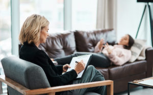 Psychologist writing notes during a psychotherapy session with her patient