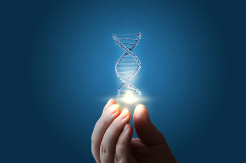 Hand holding a crystal rendering of DNA in front of blue background