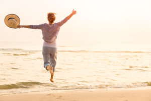 Happy woman jumping for joy after depression treatment leads to remission.
