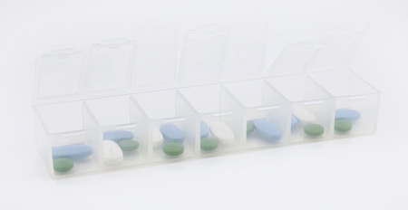 Weekly pill organizer with medication in each slot against white background, showing how polypharmacy can impact geriatric depression treatment.