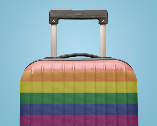 Rainbow striped suitcase against a blue backdrop signifying the journey an LGBTQ+ individual might take.