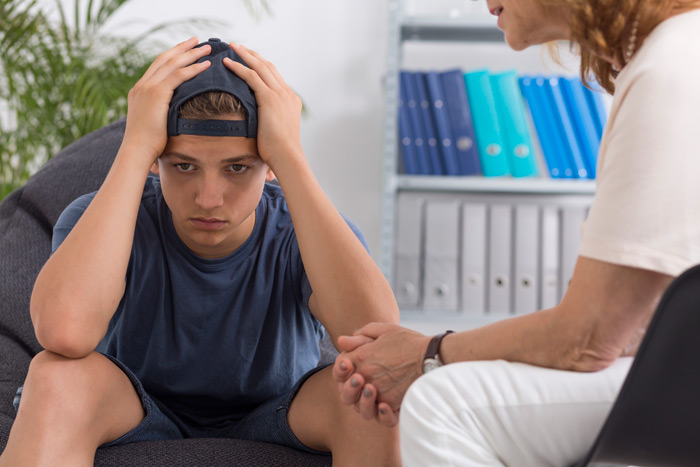 therapist speaking with a pediatric patient about mental health