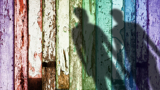 Rainbow-color weathered wood with shadow of two men holding hands