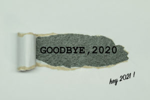 Ripped paper reveals words “Goodbye, 2020” with text written, “hey 2021!” in forefront.