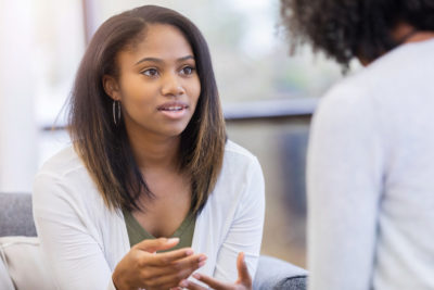Black woman in mental health therapy session, showing how counseling can help with racism.