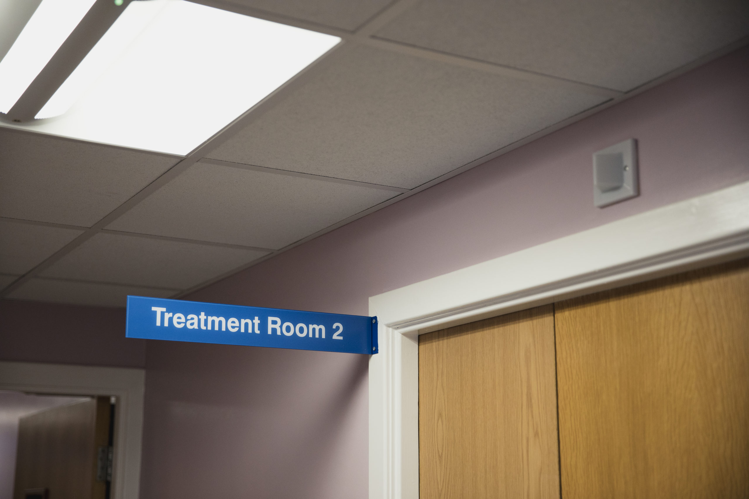 Sign in hallway reading “treatment Room 2” illustrating need for professional treatment for depression.