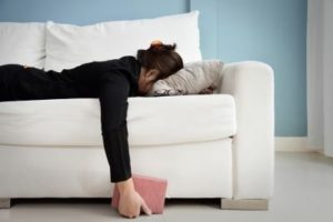 Woman lying face down on a white couch, illustrating how depression can come out of nowhere