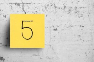 Yellow sticky note with "5" written on stuck to concrete wall, demonstrating concept of 5 signs your antidepressant isn't working