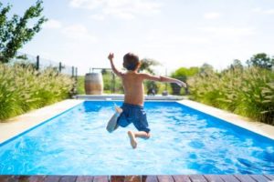 Picture of boy jumping into a swimming pool from behind, showing how to find hope when a child's mental health suffers.