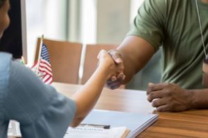 Young Army soldier shakes hand with therapist, discussing suicide prevention in veterans