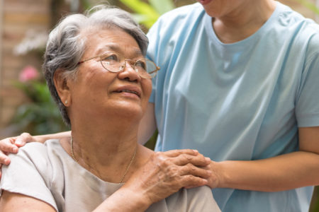 Woman looks up at her caregiver, showing importance of avoiding caregiver burnout.