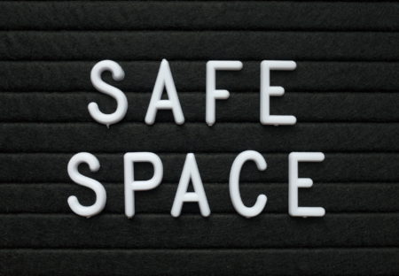 The words Safe Space in white plastic letters on a black letter board to indicate a place or environment where LGBTQ+ people can feel protected