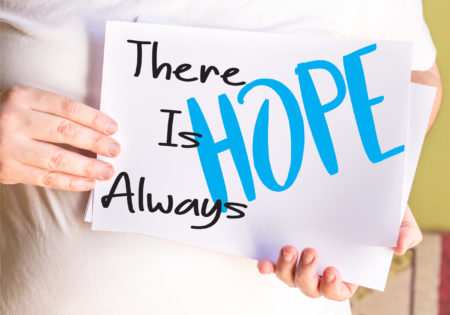 Patient holding a sign that reads “There is always HOPE”