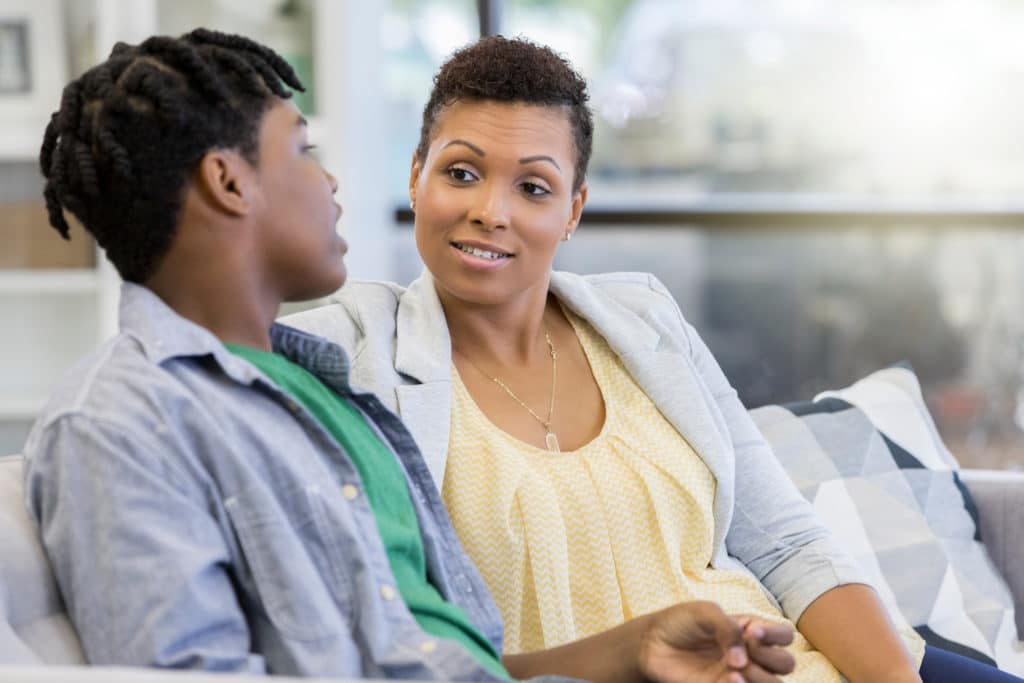 Attentive mom listens as her teenage son discuss mental health issues