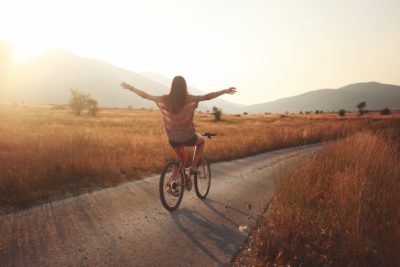 image of toned young brunette on a bicycle, lit by the Autumn sunset, showing how anxiety can be treated.