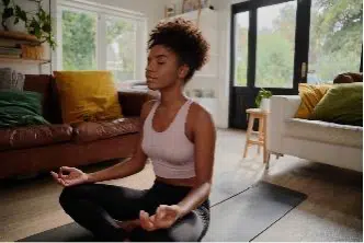 Young woman sitting on yoga mat meditating in lotus position using meditation for anxiety