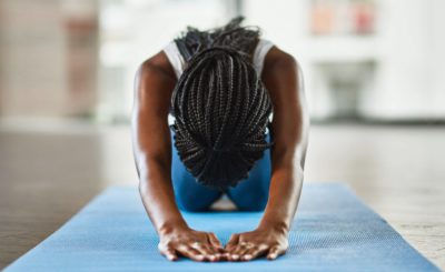 Black woman practices yoga, showing how mindfulness may help with sports anxiety symptoms.