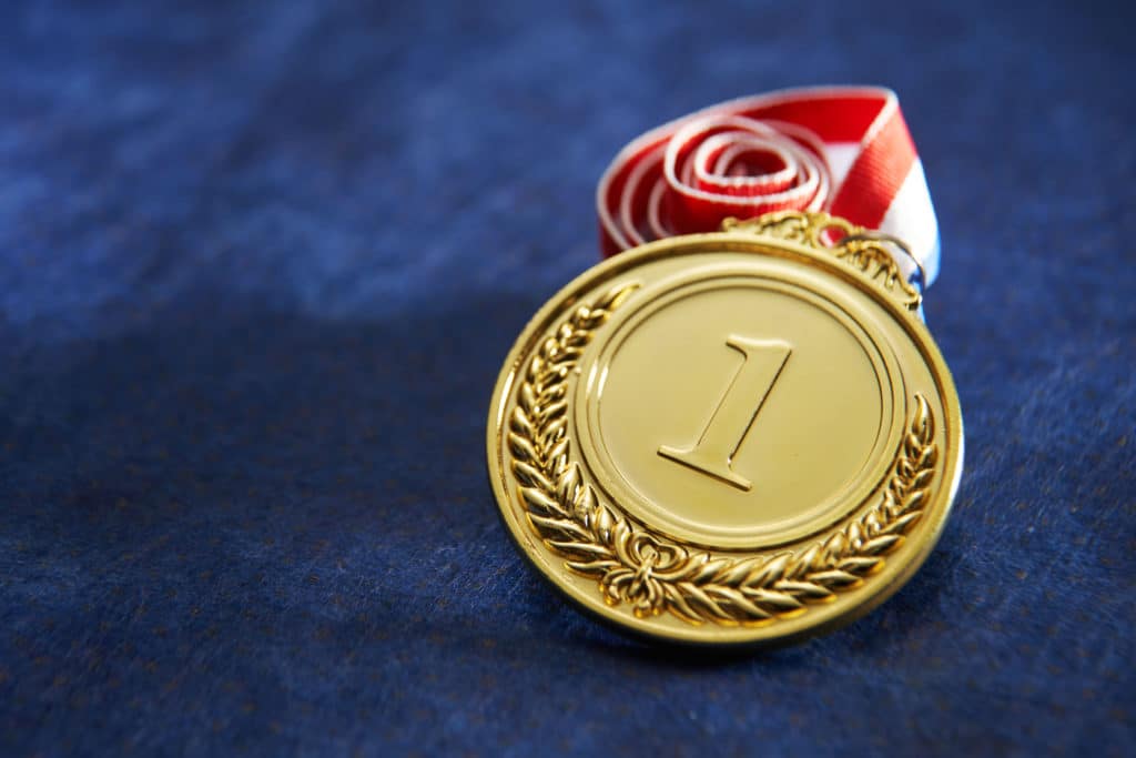 Gold medal against a navy backdrop, signifying the pressure to perform and sports anxiety symptoms.