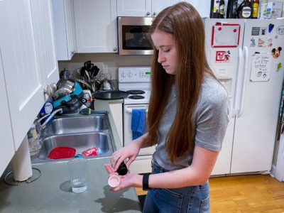 Ansley Fancher takes prescription medication for mental health condition in her kitchen, reflecting need to reach out for mental health help when needed.