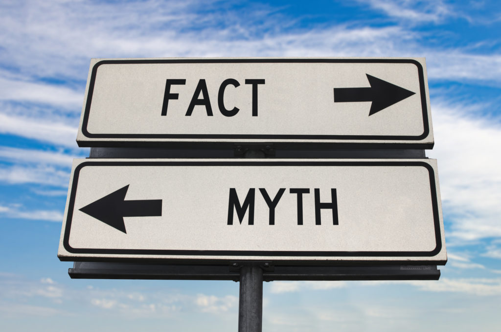 Fact versus myth road sign with two arrows on blue sky background, showing importance of understanding mental health myths.