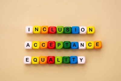 Inclusion, acceptance and equality words made from colorful wooden cubes.