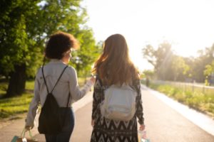 Two friends talk while walking away from the camera, showcasing how friends support can help manage anxiety.