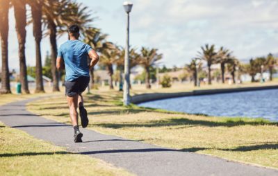 : Active male running in a park, showing importance of exercise in managing anxiety symptoms.
