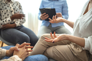 Close-up of people communicating in a support group, illustrating the importance of taking care of yourself while taking care of loved one with depression. 