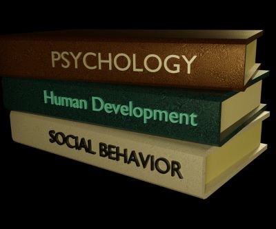Isolated pile of psychology books illustrating training for psychiatrist vs therapist
