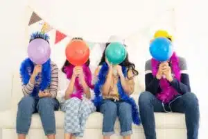 Family with balloons in front of their faces, demonstrating how some may feel anxious when getting together at social gatherings