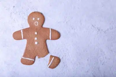 Gingerbread man cookie with broken leg and surprised face, illustrating how some may face increased social anxiety around holidays