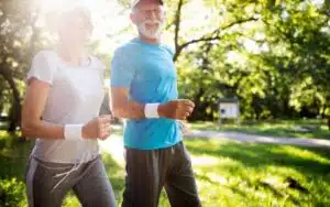Two seniors exercising in park showing how being physically active may help in geriatric depression