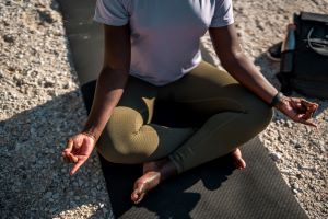A woman meditates in lotus position to help ensure she is living in the moment with anxiety and depression