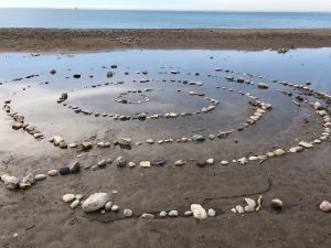 Labyrinth on a beach made of stones representing using mindfulness and intentions for mental health