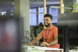 Front view of young South Asian businessman working in modern office 