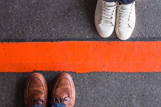 image of shoes on the bottom side of a painted line, indicating the importance of setting boundaries with family during the holidays. 