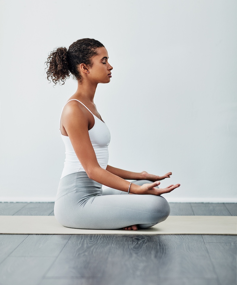 young black woman seated in lotus position indicating the importance of body scans to controlling anxiety