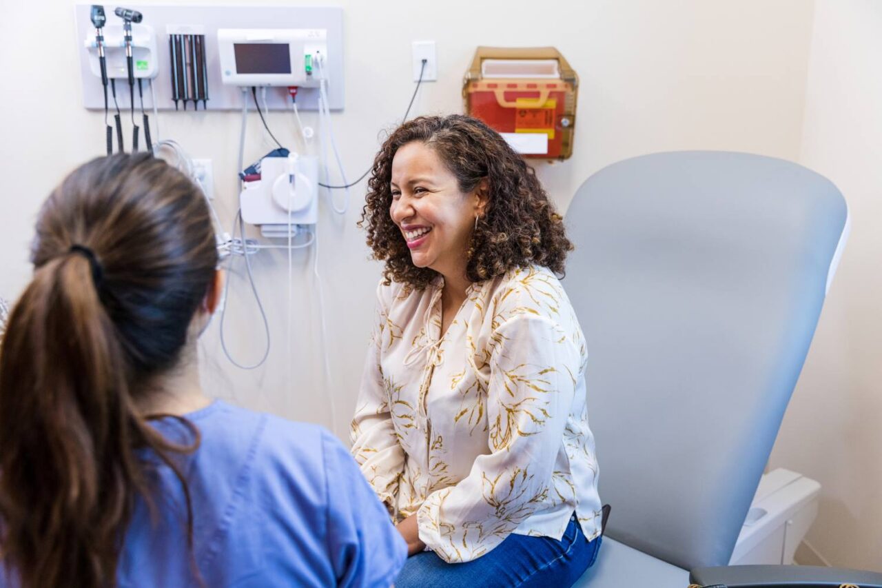 Primary care doctor talking with patient in exam room about their mental health