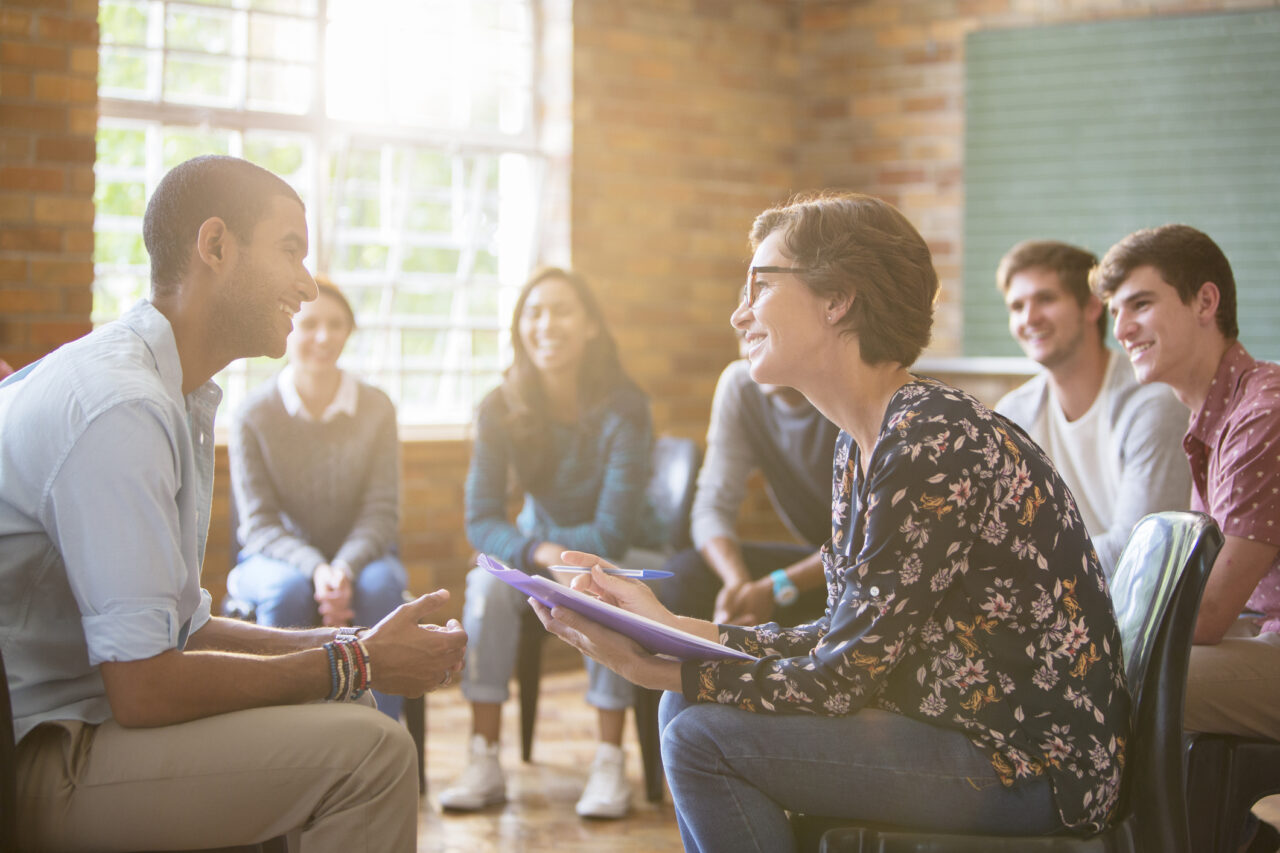 Group therapy session with young people and therapist indicating the importance of mental wellness with medications as an increasing option.