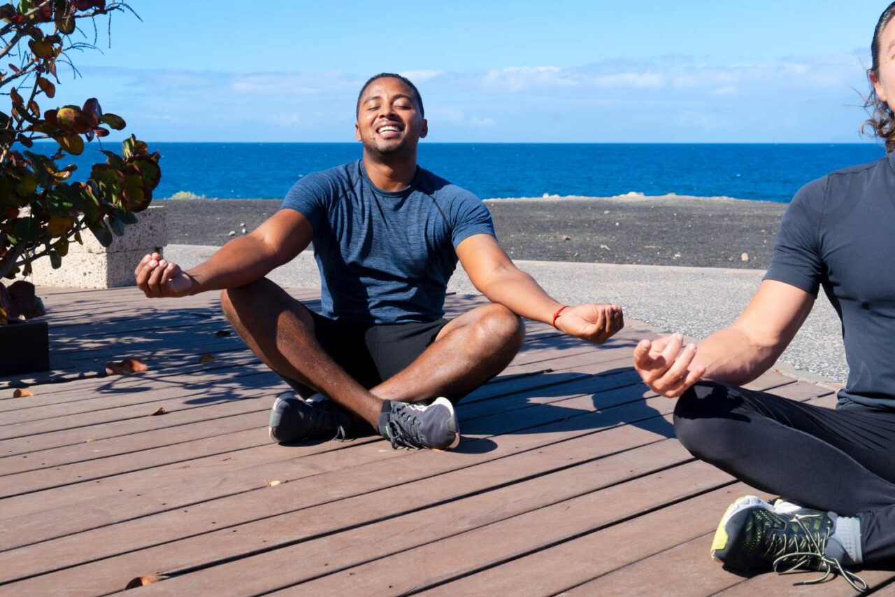 Young man meditating on a beach.